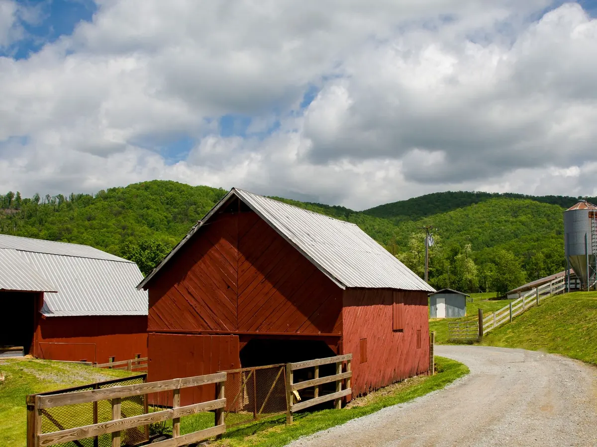 A red barn and farm buildings in green countryside