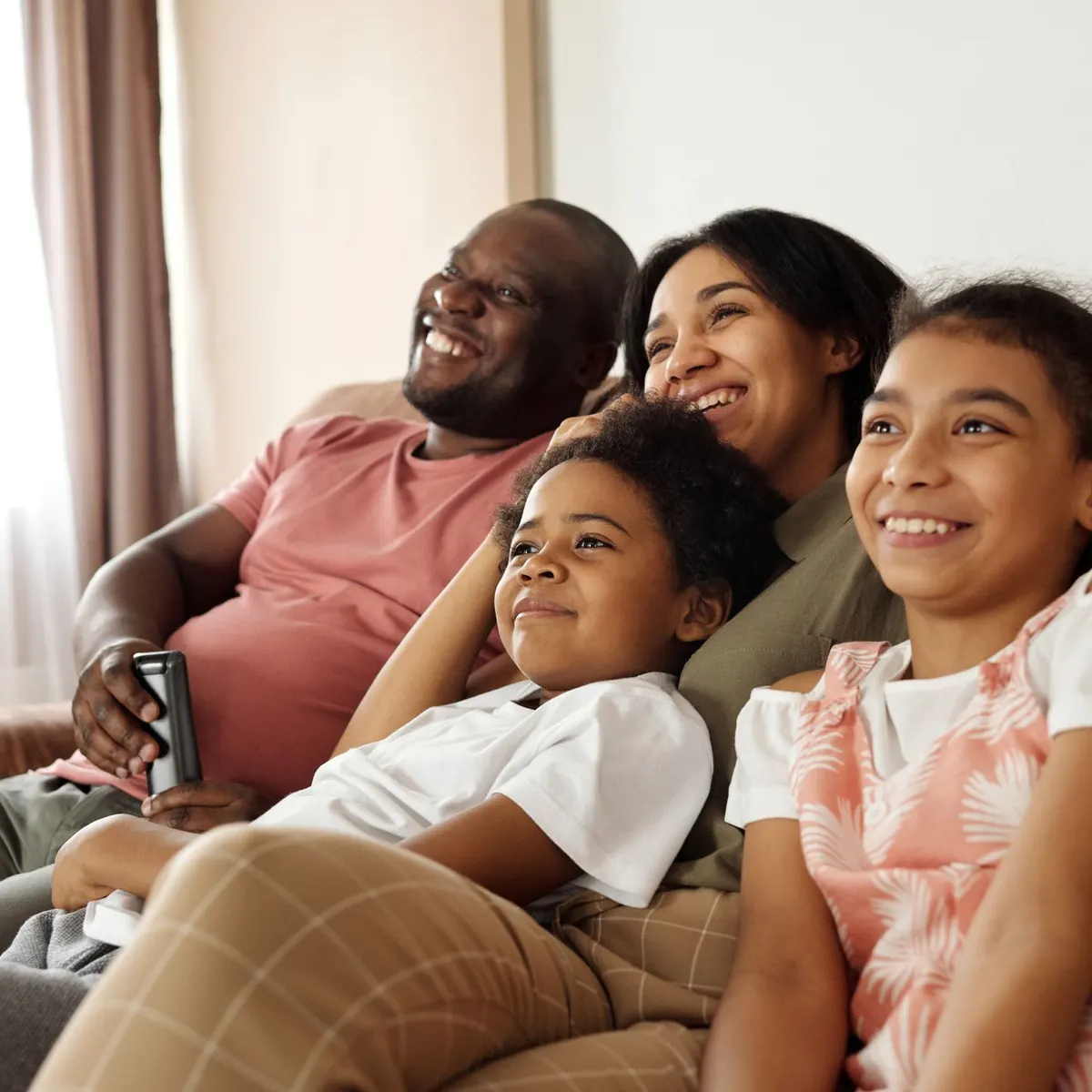 A family laughing together on the couch at home